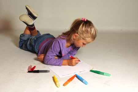 The little girl with blond hair drawsの写真素材