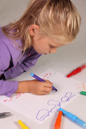 The little girl with blond hair drawsの写真素材