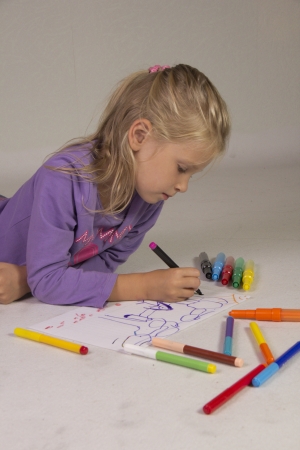 The little girl with blond hair drawsの写真素材