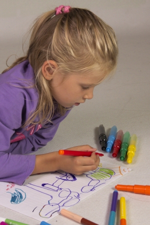 The little girl with blond hair drawsの写真素材