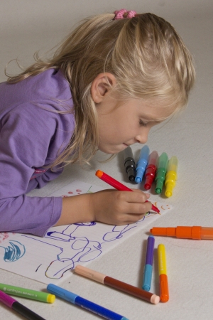 The little girl with blond hair drawsの写真素材