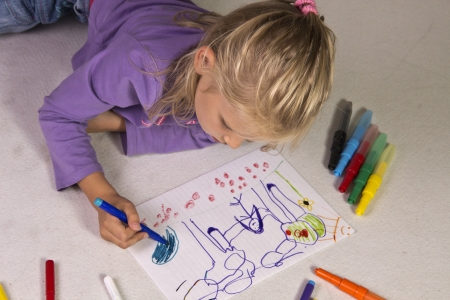 The little girl with blond hair drawsの写真素材