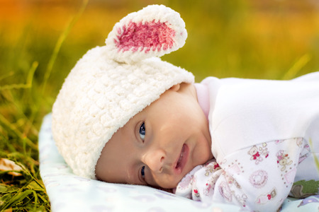 The Baby is lying on the green grass.の写真素材