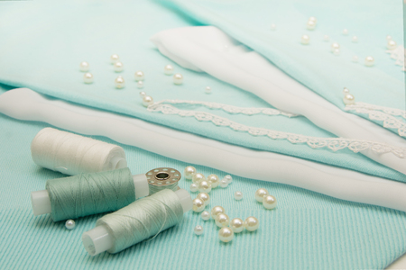 the thread, the beads, the lace are on the turquoise backgroundの写真素材