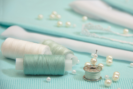 the thread, the beads, the lace are on the turquoise backgroundの写真素材