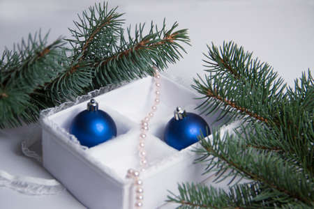 The Christmas decoration on a white background in a beautiful package. The New Year's gifts with a sprig of spruceの写真素材