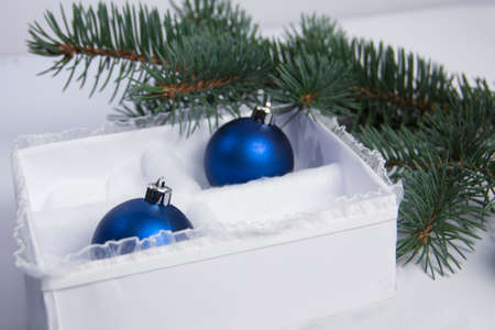 The Christmas decoration on a white background in a beautiful package. The New Year's gifts with a sprig of spruceの写真素材