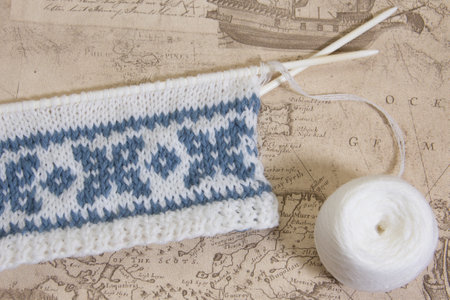 Blue knitted pattern textured background. Unfinished knitting of children's clothing with a pattern.