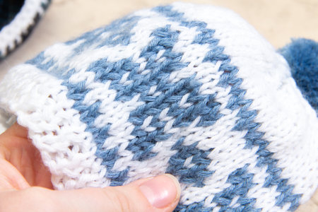 knitting patterns with knitting needles from woolen thread for a baby in light colors. knitting with needles according to a patternの写真素材