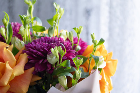 lilac dahlias with yellow roses in a bouquet on a light background close-up. bouquet of dahlias and roses on a light backgroundの写真素材