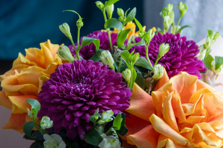 lilac dahlias with yellow roses in a bouquet on a light background close-up. bouquet of dahlias and roses on a light backgroundの写真素材