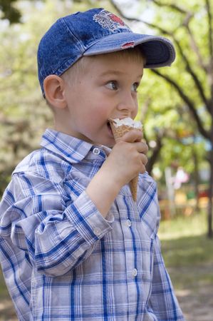little boy eats tasty ice-cream outdoorの写真素材