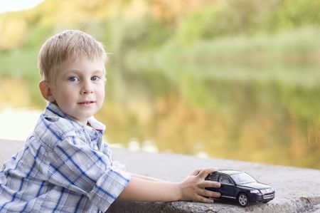 little boy play with a car outdoorの写真素材