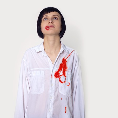 girl with lipstick trace and heart wound in white shirt in studioの写真素材