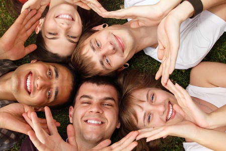 students faces happy friends group lying on green grass make ring of hands 