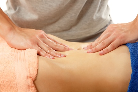 masseur makes belly massage young woman isolated on white backgroundの写真素材