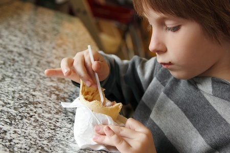 boy child cute eating ice cream in cafeの写真素材