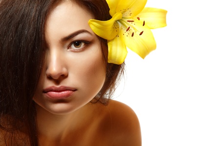 beautiful spa young multiracial woman with yellow flower lily in her hair. Isolated on white backgroundの写真素材
