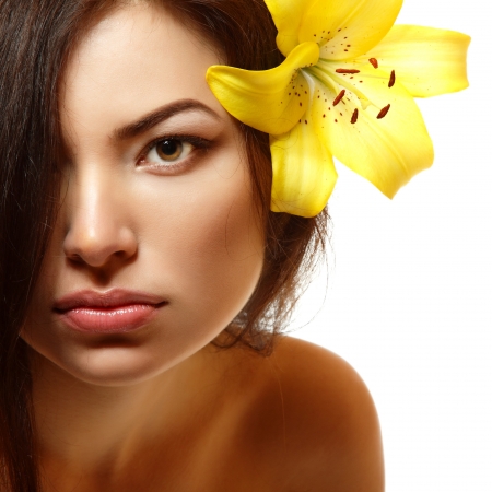 beautiful spa young multiracial woman with yellow flower lily in her hair. Isolated on white backgroundの写真素材