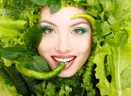 woman beauty face with greens vegetables and pepper frame isolated on white backgroundの写真素材