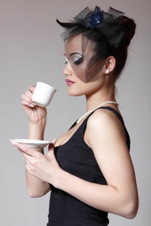 Beautiful woman in veil retro glamour beauty portrait with cup of tea or coffeeの写真素材