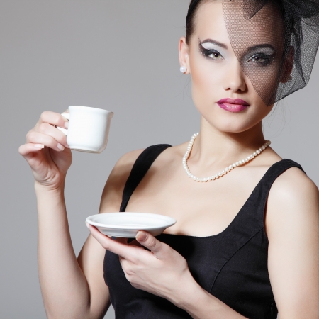 Beautiful woman in veil retro glamour beauty portrait with cup of tea or coffeeの写真素材