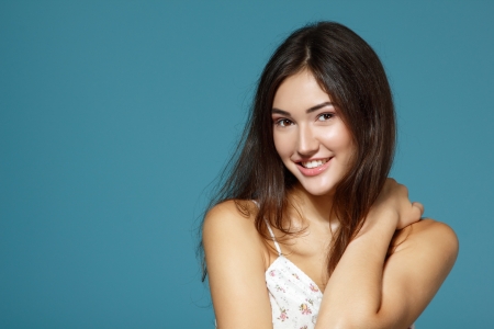beautiful happy smiling teen girl portrait over blue backgroundの写真素材
