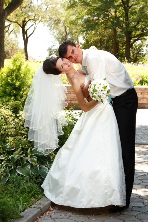 beautiful happy young bride and groom hug in love summer park outdoorの写真素材