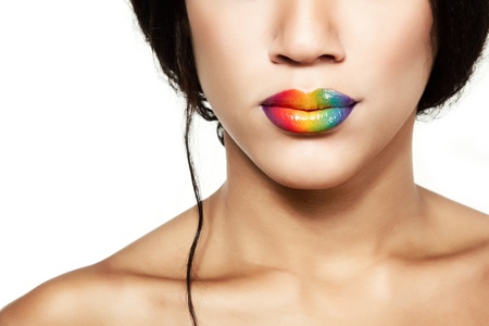 Beauty portrait of beautiful young mulatto fresh woman with rainbow lipstick, detail of face and shoulders closeupの写真素材
