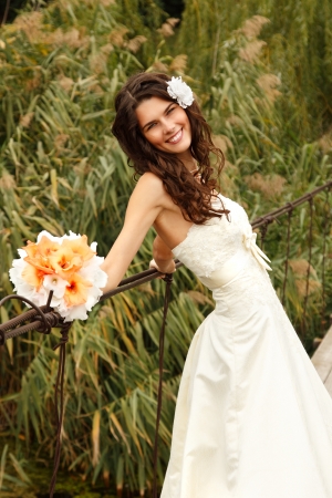 young beautiful woman bride's portrait on the bridge, summer nature outdoorの写真素材