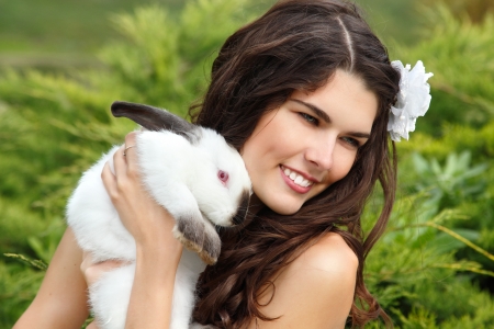 Young woman bride smiling and holding cute rabbit over park summer nature outdoor, Alice in Wonderlandのeditorial素材