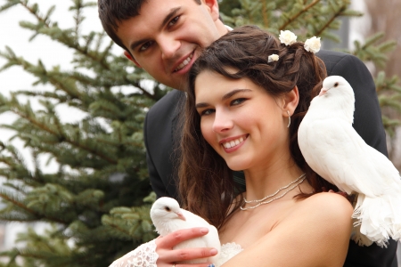 Young attractive wedding couple with pigeons pair, broom and bride over park autumn outdoorの写真素材