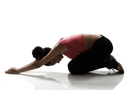 sport girl doing stretching and relaxing exercise, silhouette studio shot over white backgroundの写真素材