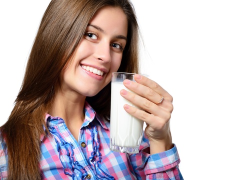beautiful cheerful teen girl drinkink milk over white backgroundの写真素材