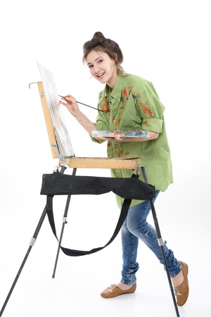 teen girl painter drawing portrait with oil paints,  professional painter at work over white bacgroundの写真素材