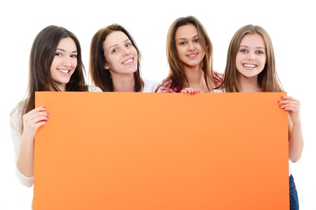 happy teen girls holding big orange empty banner over whiteの写真素材