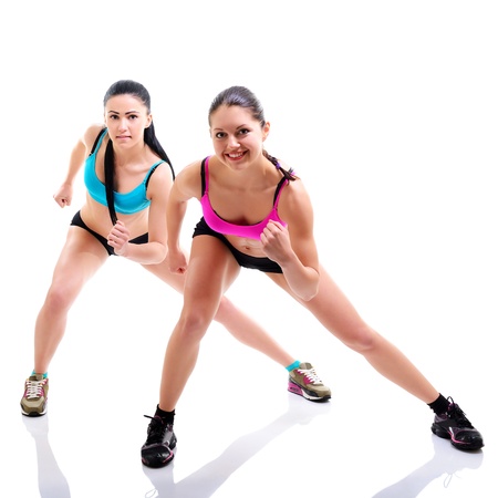 fitness girls, portrait of sport young women with perfect bodies doing exercise, studio shot over whiteの写真素材