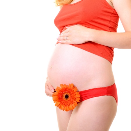 unrecognizable pregnant woman in red with deep orange flower, isolated over a white background の写真素材
