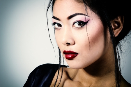 Young beautiful asian woman's portrait, studio shot toned and noise addedの写真素材