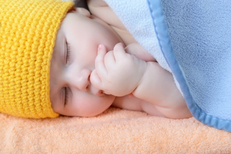 cute sleeping baby boy, beautiful kid dozing on plaid, studio shotの写真素材