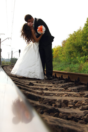 beautiful young couple bride with groom in love on railway, summertimeの写真素材