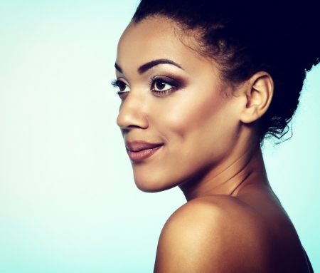 Beauty portrait of young mulatto fresh fashion woman with beautiful makeup, over blueの写真素材
