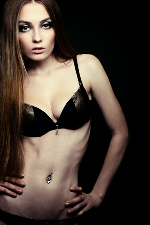 Beautiful young woman posing in bra and bikini, fashion girl over blackの写真素材