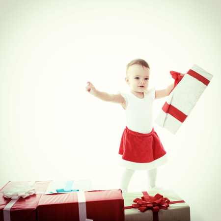Holidays, baby girl with presents, christmas, birthday, new year, x-mas concept - happy child girl with gift boxes, tonedの写真素材