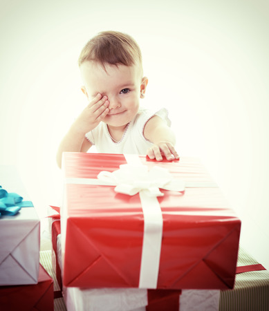 Holidays, baby girl with presents, christmas, birthday, new year, x-mas concept - happy child girl with gift boxes, tonedの写真素材