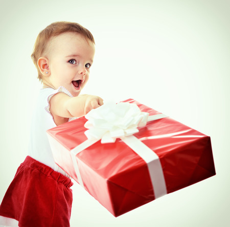 Holidays, baby girl make a present, christmas, birthday, new year, x-mas concept - happy child girl with gift boxes, tonedの写真素材
