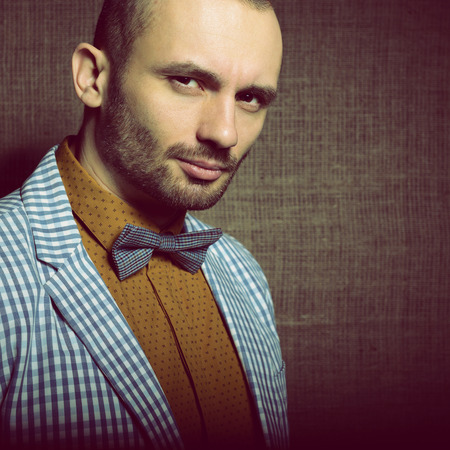 Portrait of handsome stylish man in trendy clothers, over canvas background, tonedの写真素材