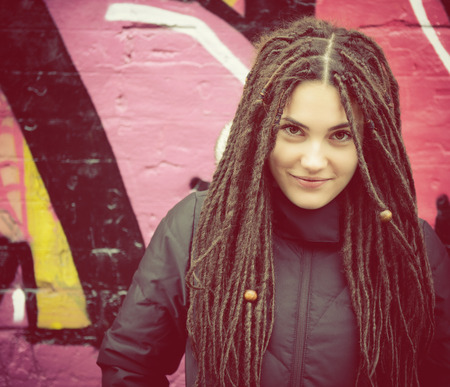 Portrait of beautiful cool girl over grunge wall 