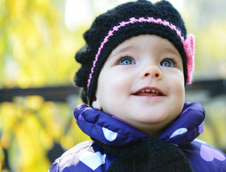 Cute liitle girl playing in autumn park, nature outdoor