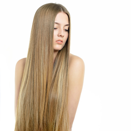Hair. Beautiful woman with long healthy shiny smooth hair. Attractive blond girl posing over white background. Gorgeous Hair. Hair care.の写真素材
